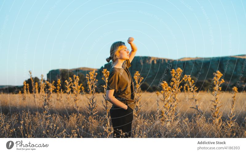 Verträumte junge Frau, die sich auf einer Wiese an einem sonnigen Tag erholt sich[Akk] entspannen Landschaft selbstbewusst Reisender Feiertag feminin Natur