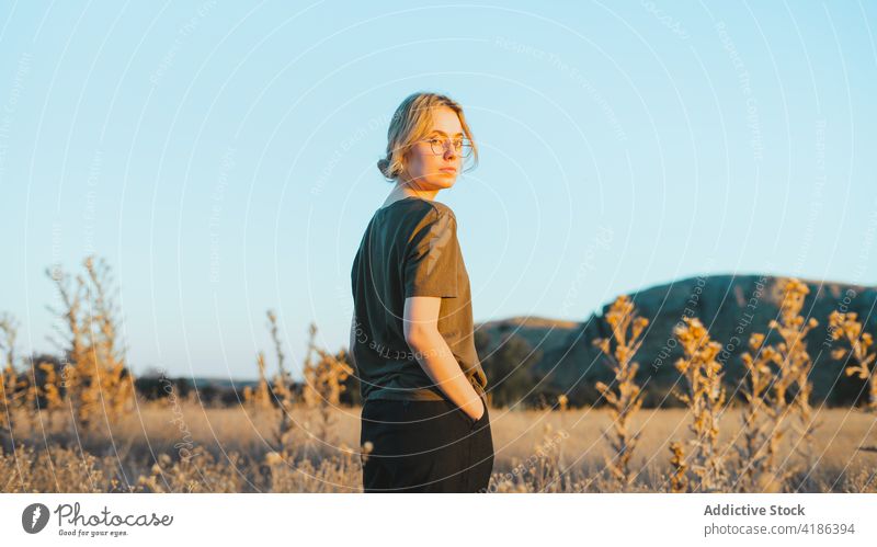 Verträumte junge Frau, die sich auf einer Wiese an einem sonnigen Tag erholt sich[Akk] entspannen Landschaft selbstbewusst Reisender Feiertag feminin Natur