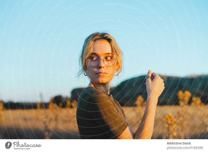 Verträumte junge Frau, die sich auf einer Wiese an einem sonnigen Tag erholt sich[Akk] entspannen Landschaft selbstbewusst Reisender Feiertag feminin Natur