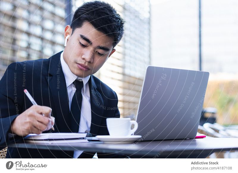 Seriöser männlicher Unternehmer im Anzug arbeitet in einem Cafe Geschäftsmann zur Kenntnis nehmen Notebook Café Arbeit abgelegen Plan Veranstalter schreiben