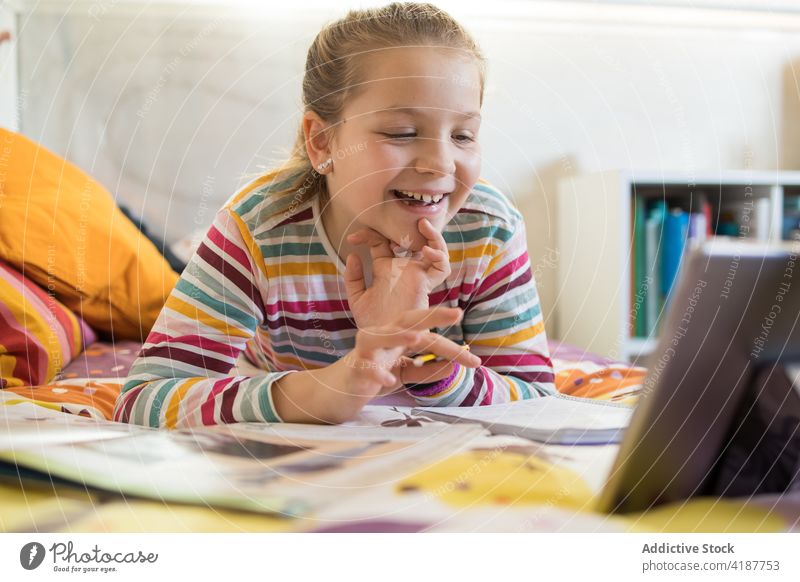 Mädchen im Gespräch mit Klassenkameraden per Videochat über ein Tablet Schulmädchen Videoanruf Lektion online lernen Video-Chat Zusammensein Tablette Anruf