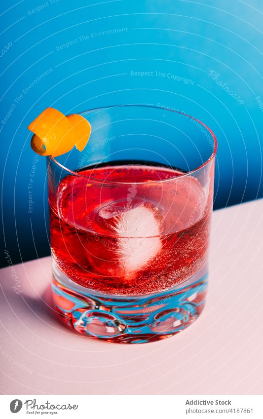 Glas erfrischender klassischer Negroni-Cocktail auf heller Oberfläche negroni Alkohol bitter orange Erfrischung Mischung kalt Zitrusfrüchte lecker mischen