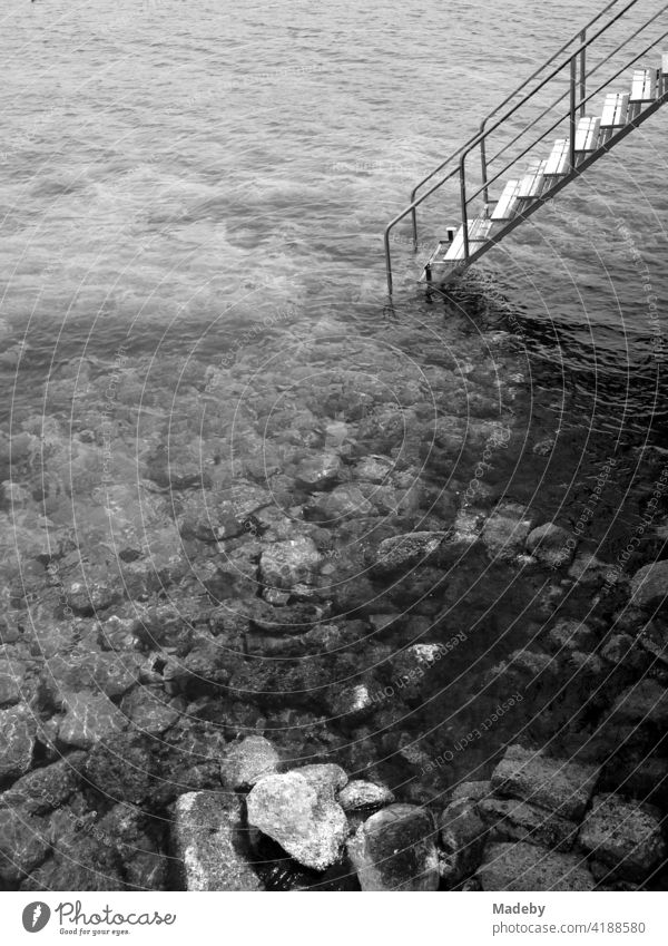 Badetreppe in der Bucht von Alacati am Ägäischen Meer in der Provinz Izmir in der Türkei, fotografiert in neorealistischem Schwarzweiß Strand Wasser Steinstrand