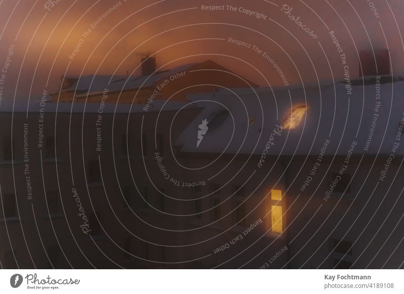 schneebedeckte Dächer und leuchtende Fenster in der Stadt im Winter Unfall Aufmerksamkeit Schneesturm blau Gebäude Gebäudeaußenseite Großstadt Stadtleben