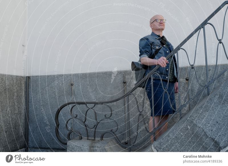 Mann in Jeansjacke und Jeansrock steht auf einer Treppe Mode Individualist Lifestyle Mensch Erwachsene Farbfoto Außenaufnahme Stil Tag kreativ Modebewusst