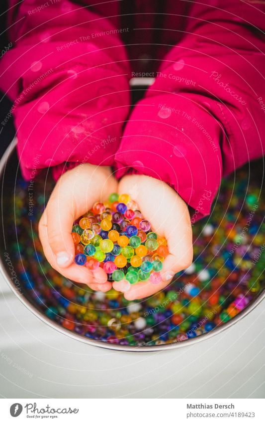 Mädchen spielt mit Wasserperlen Kind Hand Kinderhand Kinderhände Basteln matschen Spielen bunt farbenfroh Kindheit Kleinkind Finger