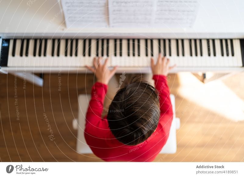 Junge spielt zu Hause Klavier Kind spielen Probe Gesang Musik Musiker Hinweis Melodie heimwärts lernen sitzen Talent Instrument Fähigkeit üben Klang Hobby