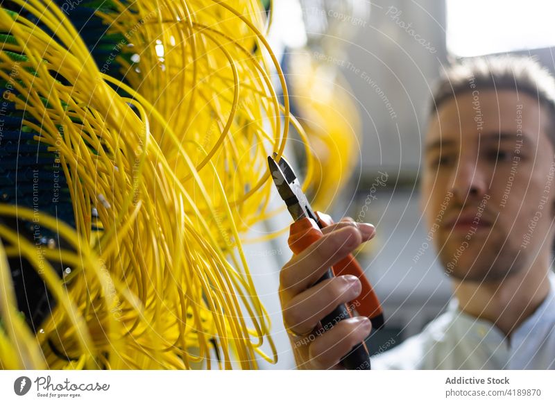 Professioneller Systemadministrator schneidet Drähte im Server Mann Ingenieur Draht geschnitten Drahtschneider Anschluss elektronisch Software Einrichtung