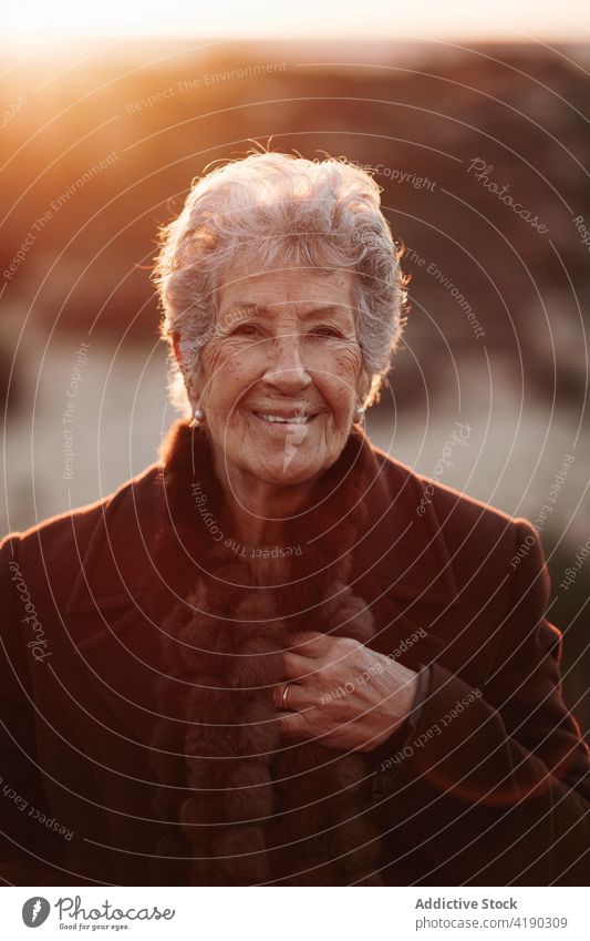 Ältere Dame bewundert den Sonnenuntergang über dem Meer von der Strandpromenade aus Frau bewundern Meereslandschaft Reisender genießen Natur Urlaub reisen MEER