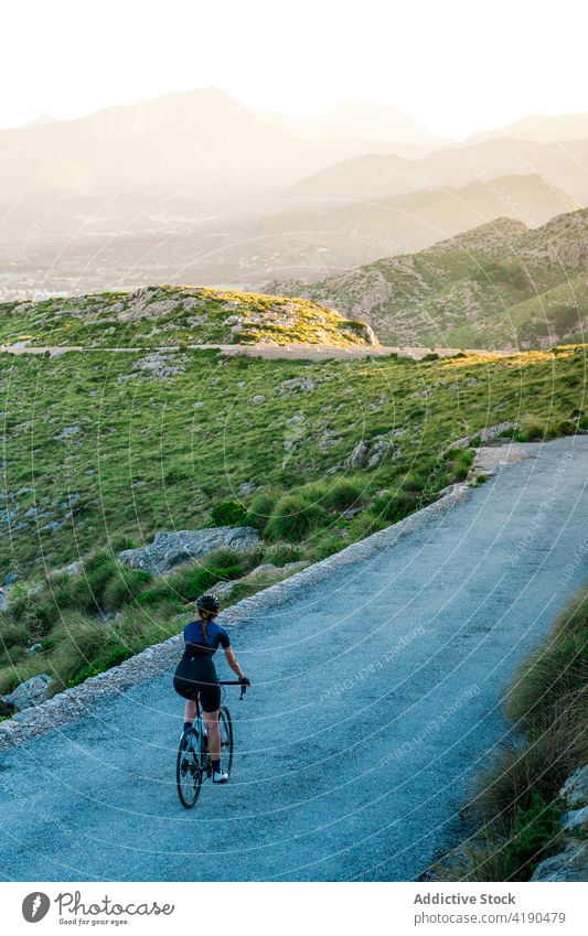 Sportliche Frau auf dem Fahrrad am Hang Mitfahrgelegenheit Radfahrer Gesundheit Erholung Natur Abenteuer aktiv allein jung Freiheit modern sorgenfrei Reise