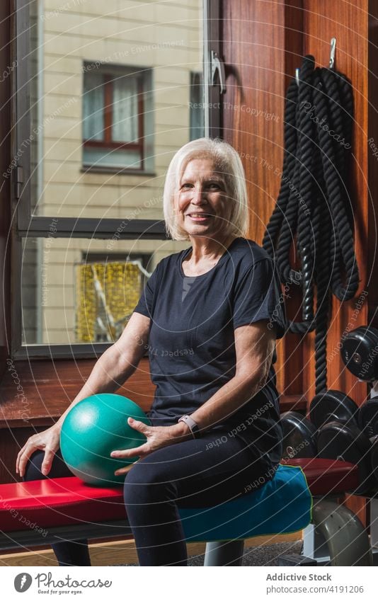 Ältere Sportlerin trainiert Arme mit Ball im Fitnessstudio gealtert Waffen Pilates Mini Training Senior Bank Reihe Passform-Ball im Innenbereich achtsam Übung