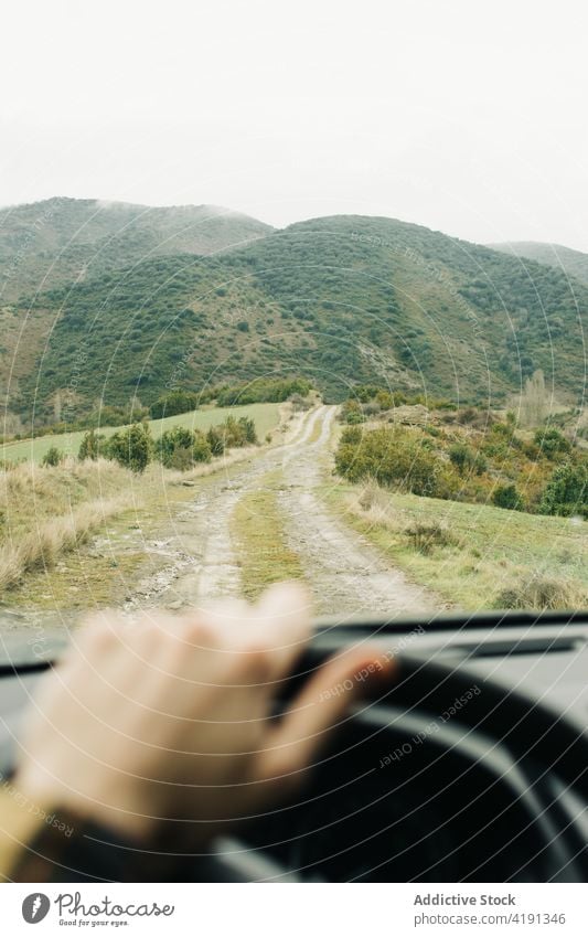 Reisende fahren mit dem Auto durch die Berge Mann Fahrer Tourist Lenkrad Hügel Ausflug Autoreise Natur Windschutzscheibe männlich reisen ländlich Straße PKW