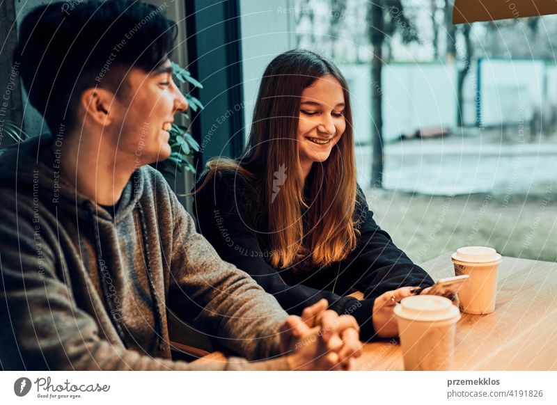 Freunde, die sich unterhalten, miteinander reden, Kaffee trinken, in einem Café sitzen. Junger Mann und Frau haben eine Pause, entspannen im Café kaufen Person