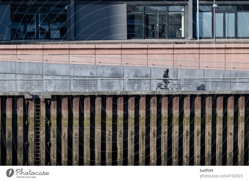 Fahrradfahren am Kai eines Hafenbeckens Radfahren spundwand Verkehr Bewegung Lifestyle Radfahrer urban Hafenanlage Schifffahrt Hafenstadt Wasser Fassade Fluss