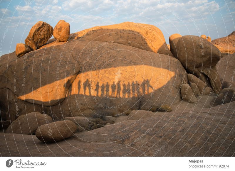 Felsen im Damaraland mit den Schatten einer Gruppe von Menschen an einem sonnigen Tag Namibia damaraland Menschengruppe genießen Glück Zusammensein wüst heiß