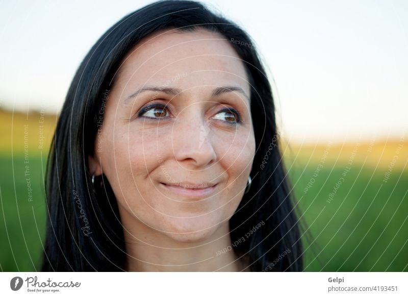 Frau, die auf die Seite schaut und sich auf einer Wiese entspannt. Mädchen Park schön Frühling besinnlich Denken Gedanke Sommer Natur im Freien Person Gesicht