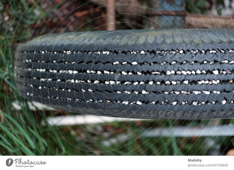 Weiße Kieselsteine in den Rillen eines alten Reifen eines Anhänger für den Traktor auf einem Bauernhof in Rudersau bei Rottenbuch im Kreis Weilheim-Schongau in Oberbayern