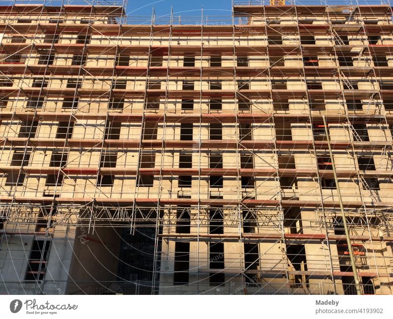 Moderner Wohnungsbau mit Fassade in Beige mit Baugerüst im Sonnenschein in Offenbach am Main in Hessen Neubau Architektur Bauprojekt Baustelle Gerüstbauer