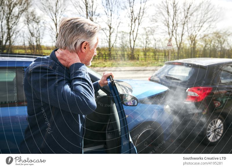 Älterer männlicher Fahrer mit Schleudertrauma, der nach einem Verkehrsunfall aus dem Auto steigt Mann PKW Unfall Schiffswrack Absturz Versicherung Anspruch