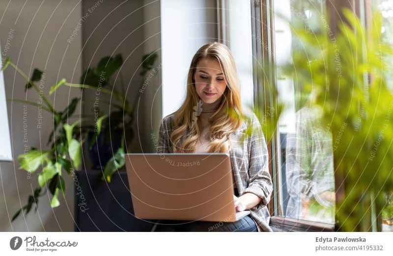 Junge Geschäftsfrau mit Laptop in ihrem Büro Frau Mädchen Menschen Unternehmer Business gelungen Erfolg professionell jung Erwachsener Lifestyle im Innenbereich