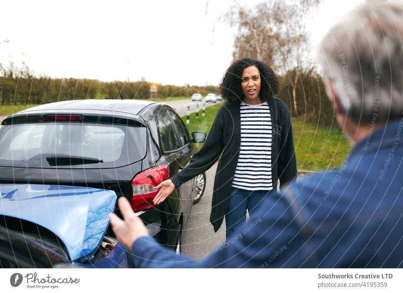 Älterer männlicher Fahrer, der über die Schuld für einen Autounfall mit einer jüngeren Autofahrerin streitet Frau Mann PKW Unfall Schiffswrack Absturz