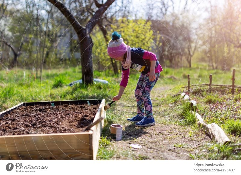 Süßes kleines Mädchen genießen Gartenarbeit in städtischen Gemeinschaftsgarten städtischer Garten umgebungsbedingt Erhaltung nachhaltig Lifestyle hausgemacht