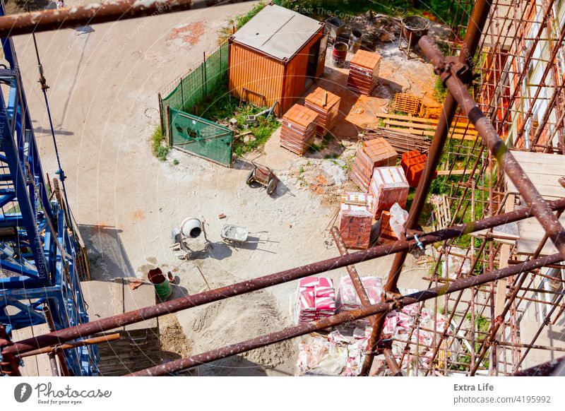 Blick von oben auf die Baustelle, Gerüst, verpackte, gestapelte Betriebsmittel Gegend Schubkarre Klotz Baustein Mauerwerk Bündel Karre Zement Tiefbau komplex