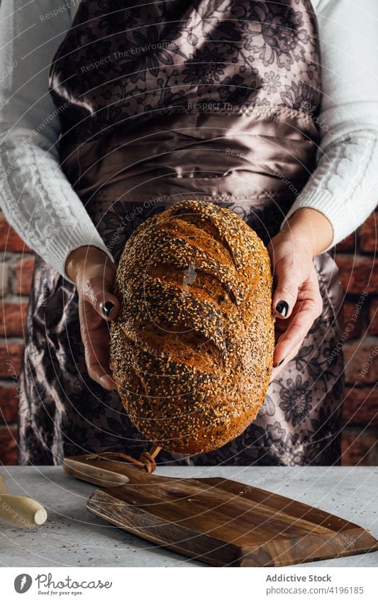 Handwerker mit Mehrkornbrot in der Bäckerei geschnitten Brot Brotlaib Nährstoff Müsli geschmackvoll Frau gebacken Kunstgewerbler sortiert Nudelholz Utensil