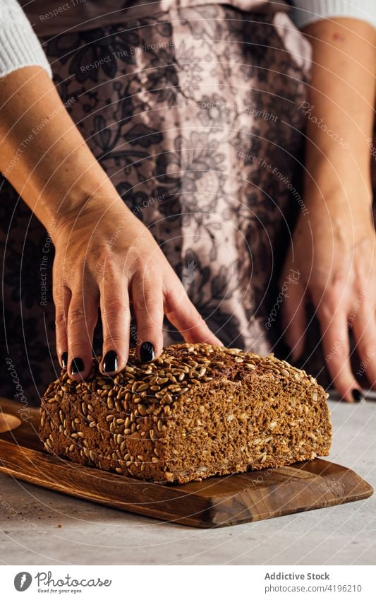 Handwerker mit Mehrkornbrot in der Bäckerei geschnitten Brot Brotlaib Nährstoff Müsli geschmackvoll Frau gebacken Kunstgewerbler sortiert Nudelholz Utensil