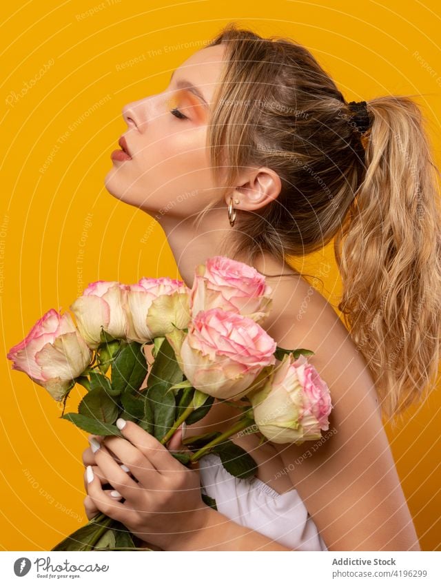 Stilvolle Frau mit rosa Rosen im Atelier stehend Roséwein Blume trendy Outfit Blüte duftig einwandfrei traumhaft sensibel schön jung attraktiv hübsch Flora