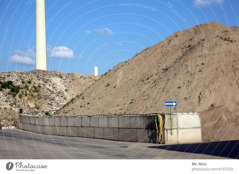 Schutt und Sandhügel Kiesgrube Einbahnstraße Industrie Baumaterial dreckig Dreck Vorrat Material abkippen Haufen hoch Hügel trocken Verkehrswege Strassenschild