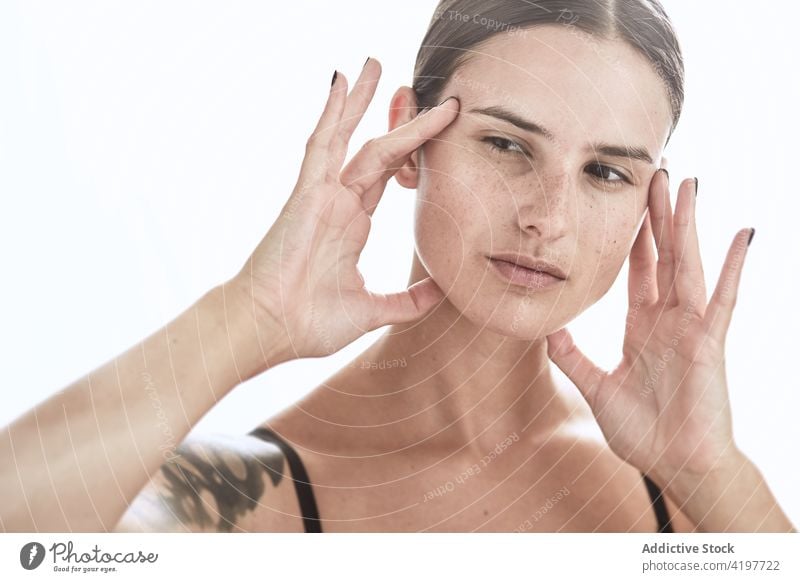 Sommersprossige Frau berührt Gesicht mit manikürter Hand Porträt Individualität sanft natürlich charmant Gesicht berühren Sommersprosse Vorschein Make-up