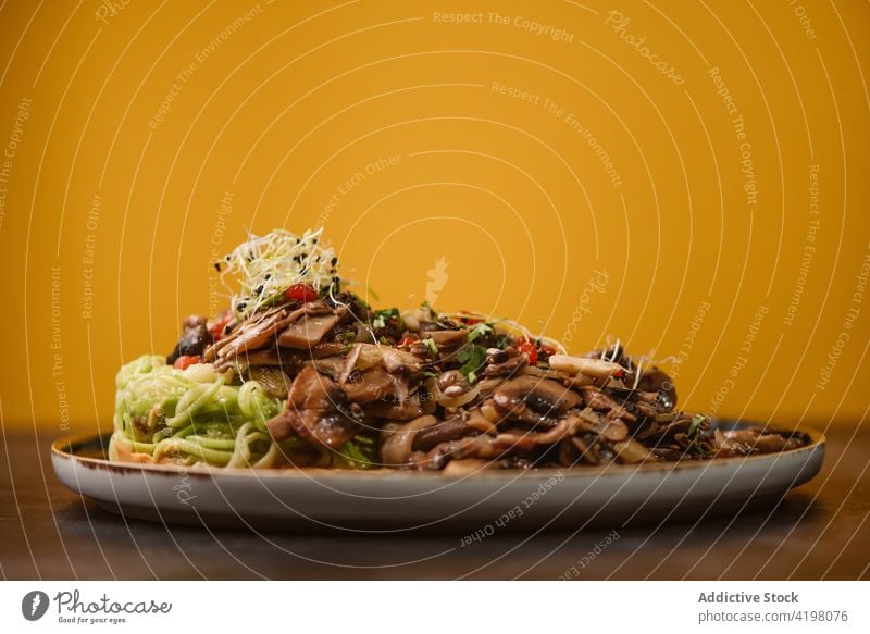 Leckeres Zucchininest mit verschiedenen Pilzen auf dem Teller Asiatische Küche Vegetarier Mahlzeit Abendessen Speisekarte Mittagessen sortiert Spaghetti Nest