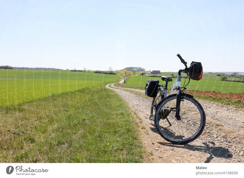 Frühlingslandschaft mit einem E-Bike auf dem Weg Fahrrad elektrisch Biker Abend Landschaft Freizeit Natur im Freien Erholung Himmel Sport Sommer Abenteuer