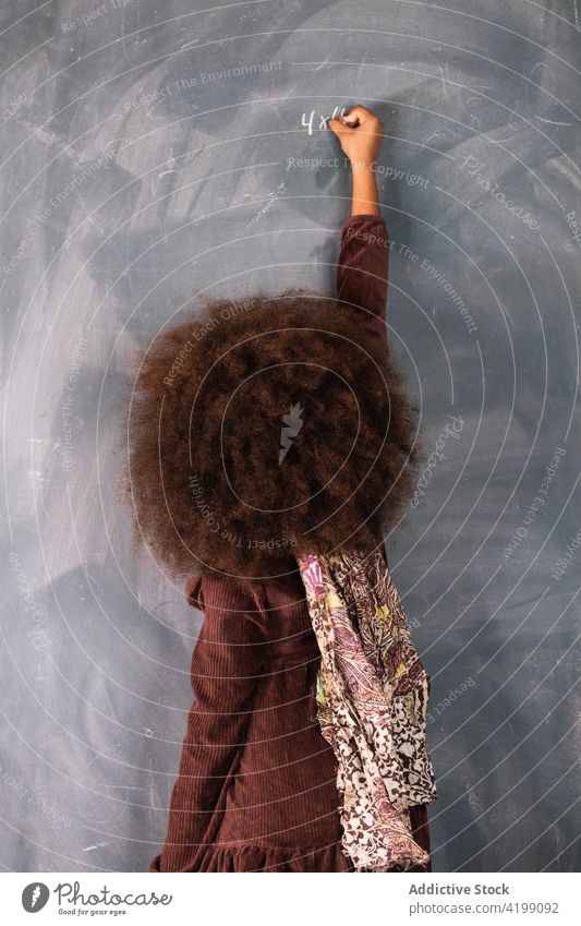 Schwarzes Mädchen schreibt auf Tafel im Klassenzimmer Pupille Mathematik Beispiel lösen schreiben Lektion ethnisch Afroamerikaner schwarz Schule Schulmädchen