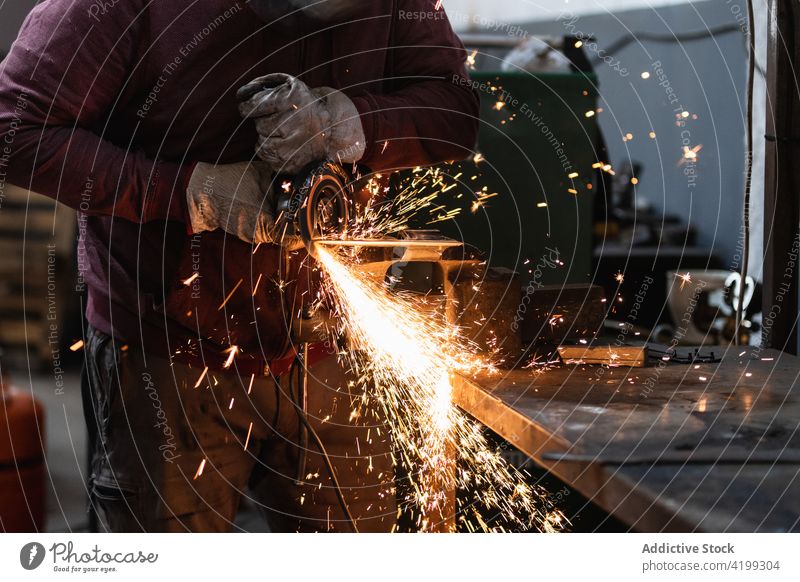 Handwerker schleift Metall mit Schleifmaschine im Schraubstock Hufschmied Funken Grinden bügeln Laster schmieden industriell Metallbearbeitung Werkzeug