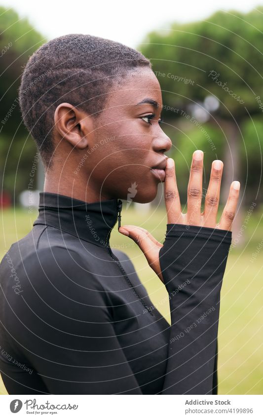 Junge zarte ethnische Frau in schwarzer Kleidung mit kurzen Haaren im Sommer feminin sanft Kurze Haare Angebot herzlich freundlich charmant angenehm Park