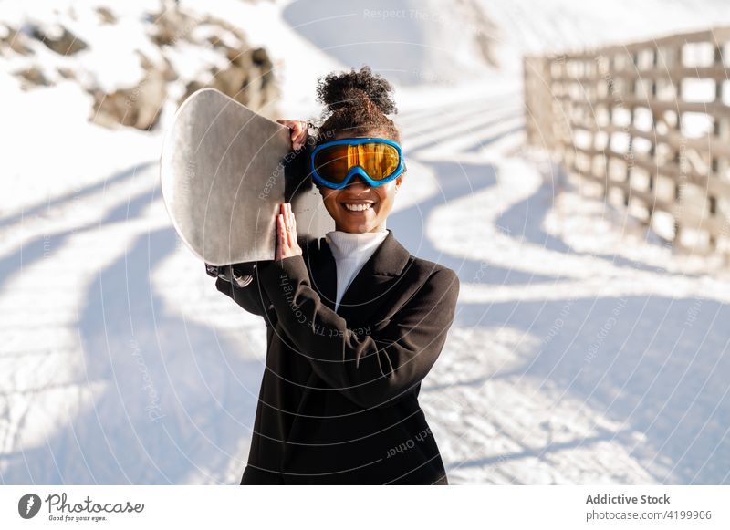 Inhalt schwarzer Sportler mit Snowboard in verschneiten Bergen Athlet Resort Stil Glück Berge u. Gebirge Natur Schnee Winterzeit Frau Reittier Hochland Zaun