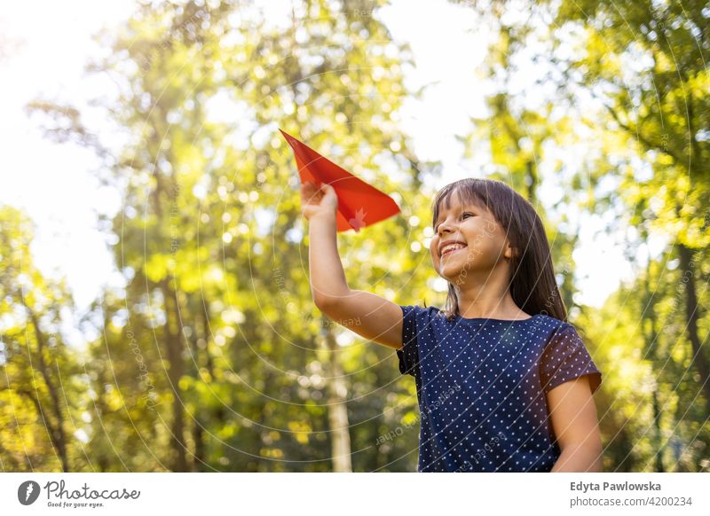 Kleines Mädchen spielt mit Papier Flugzeug im Park Menschen Kind kleines Mädchen Kinder Kindheit im Freien lässig niedlich schön Porträt Lifestyle elementar