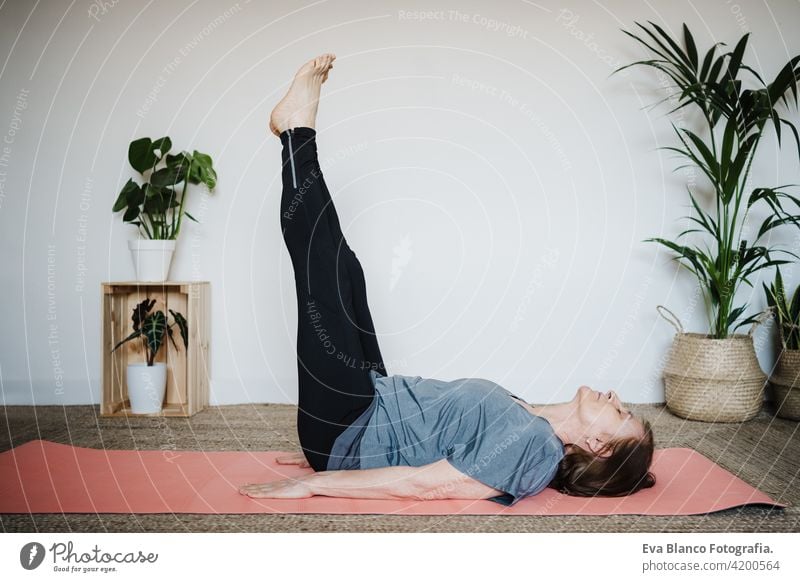 reife kaukasische ältere Frau übt Yoga-Pose zu Hause. Gesunder Lebensstil Senior heimwärts Sport Gesundheit Kaukasier Stock alt aktiv Rentnerin Fitnessstudio