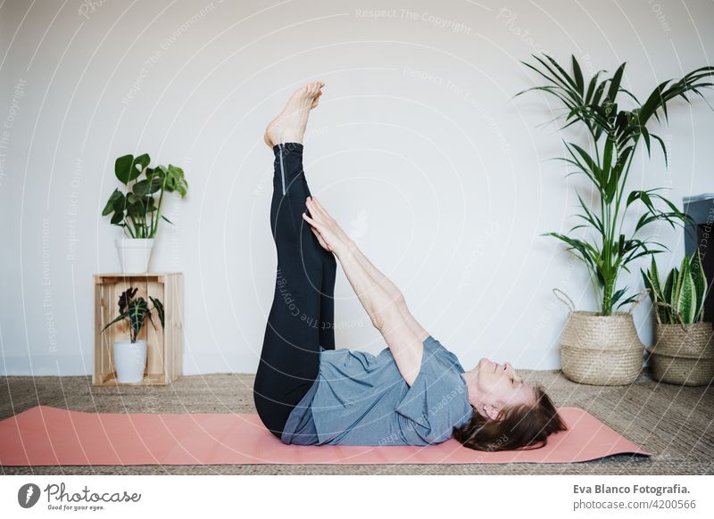 reife kaukasische ältere Frau übt Yoga-Pose zu Hause. Gesunder Lebensstil Senior heimwärts Sport Gesundheit Kaukasier Stock alt aktiv Rentnerin Fitnessstudio