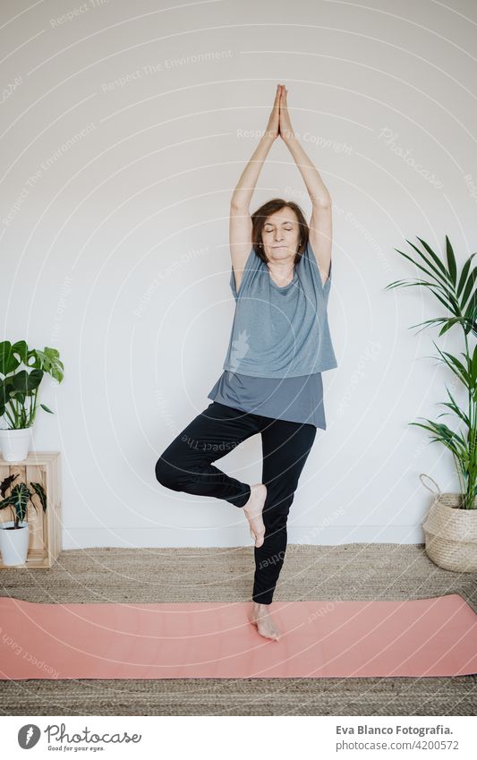 reife kaukasische ältere Frau übt Yoga-Pose zu Hause. Gesunder Lebensstil Senior heimwärts Sport Gesundheit Kaukasier Stock alt aktiv Rentnerin Fitnessstudio