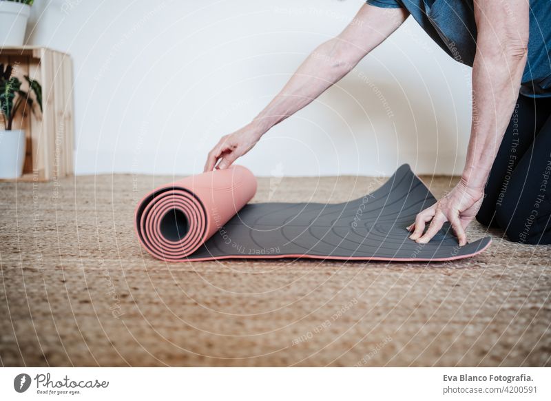 reifen kaukasischen Senior Frau bereit, Yoga zu Hause zu üben. Hält Yogamatte. Gesunder Lebensstil heimwärts Sport Gesundheit Kaukasier Stock alt aktiv