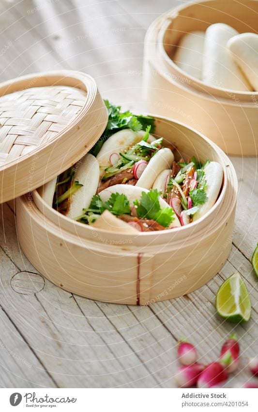 Leckere Bao-Brötchen mit Füllung in Bambusdämpfern Asiatische Küche Mittagessen Abendessen Mahlzeit Speisekarte Brotbelag lecker Dampfschiff Bapao Fleisch