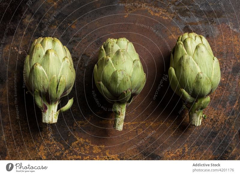 Frische Artischocken in Reihen auf dem Tisch angeordnet grün Pflanze Hälfte Ernährung reif Lebensmittel Gesundheit essbar organisch Vitamin Ernte Veganer Orden