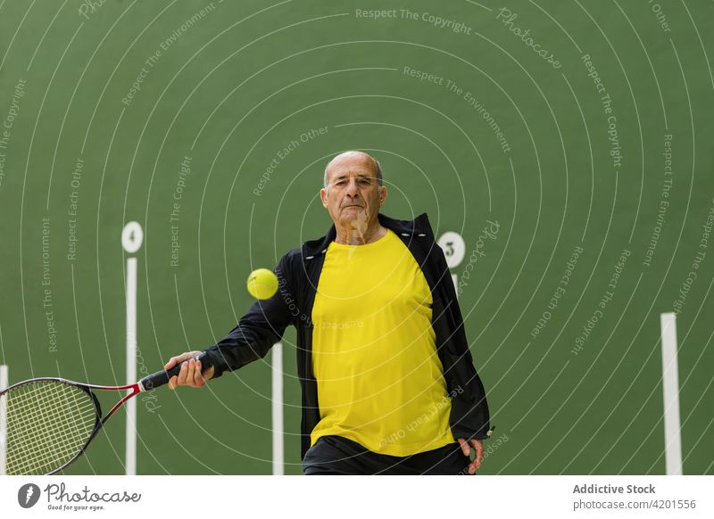 Älterer Mann spielt Tennis in der Turnhalle Sportler spielen Fitnessstudio Streichholz Training aufschlagen Ball Remmidemmi üben männlich Athlet älter Senior