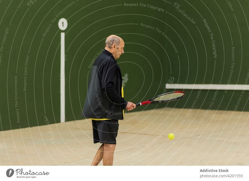 Älterer Mann spielt Tennis in der Turnhalle Sportler spielen Fitnessstudio Streichholz Training aufschlagen Ball Remmidemmi üben männlich Athlet älter Senior