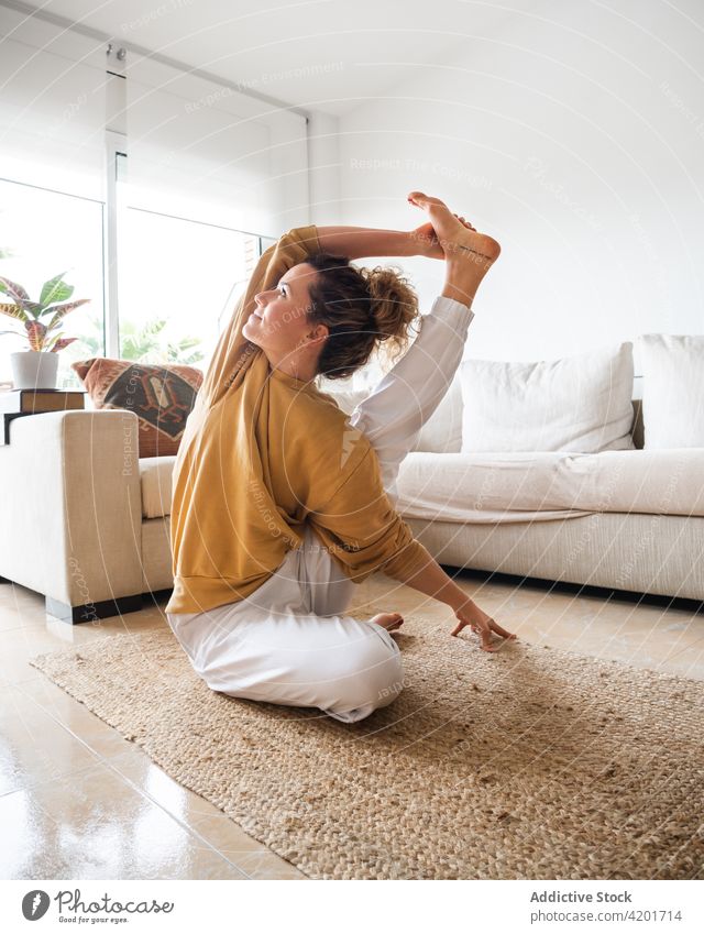 Frau in Kompass-Pose beim Yoga zu Hause Windstille Surya Yantrasana heimwärts Dehnung Asana Pose des Kompasses Wellness Aktivität Wohlbefinden Zen Konzentration