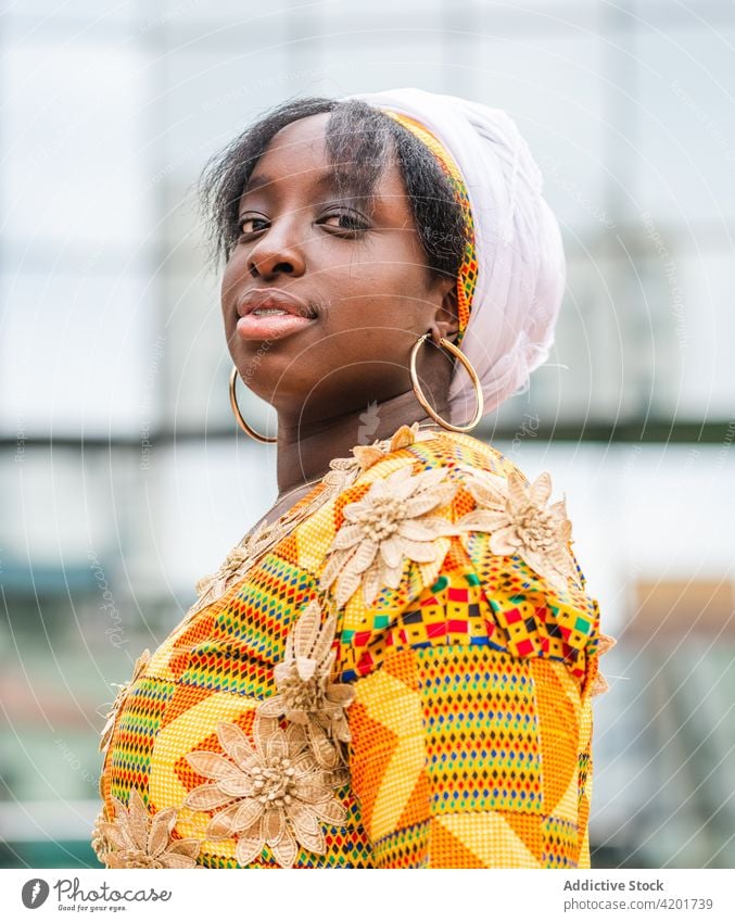 Schwarze Frau in ornamentaler Kleidung auf einer Stadtstraße Stil feminin elegant Ornament charmant angenehm sanft Großstadt Porträt schwarz Afrikanisch