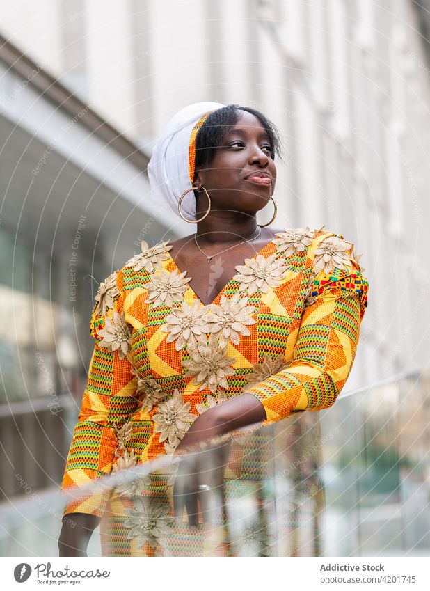 Schwarze Frau in ornamentaler Kleidung auf einer Stadtstraße Stil feminin elegant Ornament charmant angenehm sanft Großstadt Porträt schwarz Afrikanisch